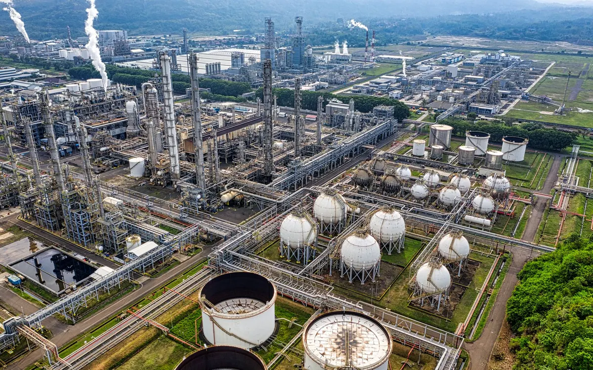 Impianto industriale con serbatoi e tubazioni visto dall’alto.