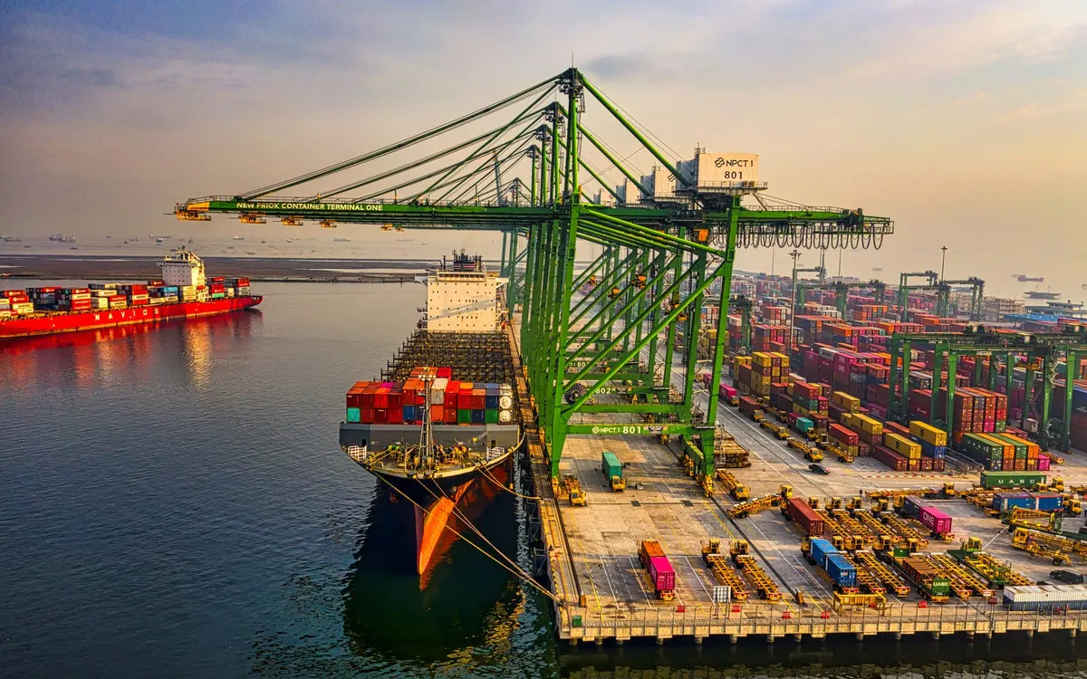 Banchina di un terminal container vista dall’alto, con una nave ormeggiata sotto le gru.